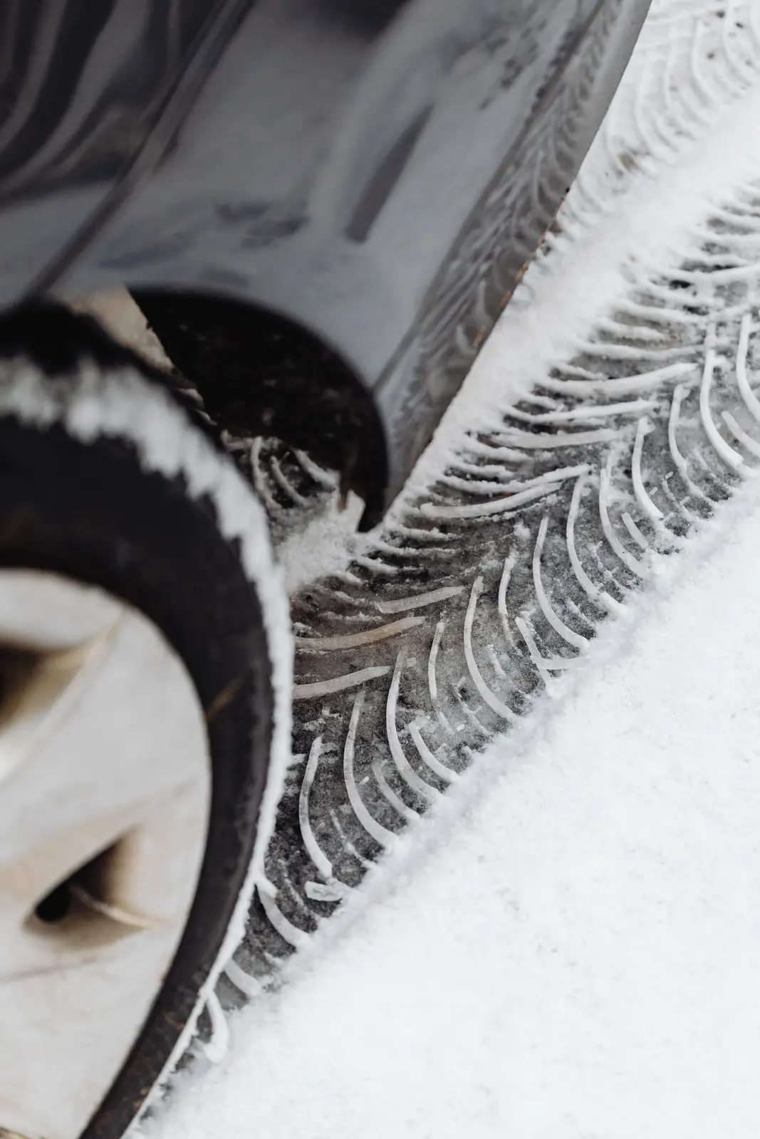 Vinterdäck i snön med däckspår bredvid